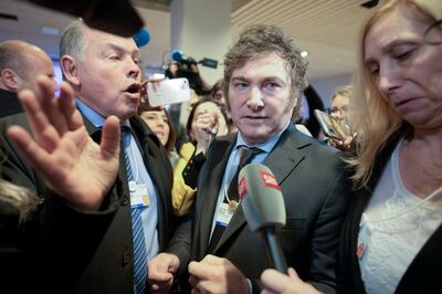 Javier Milei is mobbed by the media and supporters at the Congress centre in Davos. AP