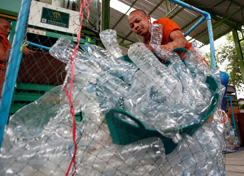 epa07696898 Thai Buddhist monks prepare recyclable plastic bottles for a pressing machine to produce recycled monk's saffron robes at Wat Chak Daeng Temple in Samut Prakan province, Thailand, 05 July 2019. Thailand's first recycled monk's saffron robes are made from used polyethylene terephthalate (PET) bottles collected by the temple's Buddhist monks, residents and donation then transform into recycle fabrics before weaving and embroidering to antibacterial robes with odors control capability. A cooperation between the temple's Buddhist monks and community members aimed to control plastic waste as part of a waste management project to support the environment protection and enhancing economic opportunities through recycled products. Thailand is one of the world's largest plastic polluters by generates more than two million tons of plastic waste each year.  EPA/RUNGROJ YONGRIT  ATTENTION: This Image is part of a PHOTO SET