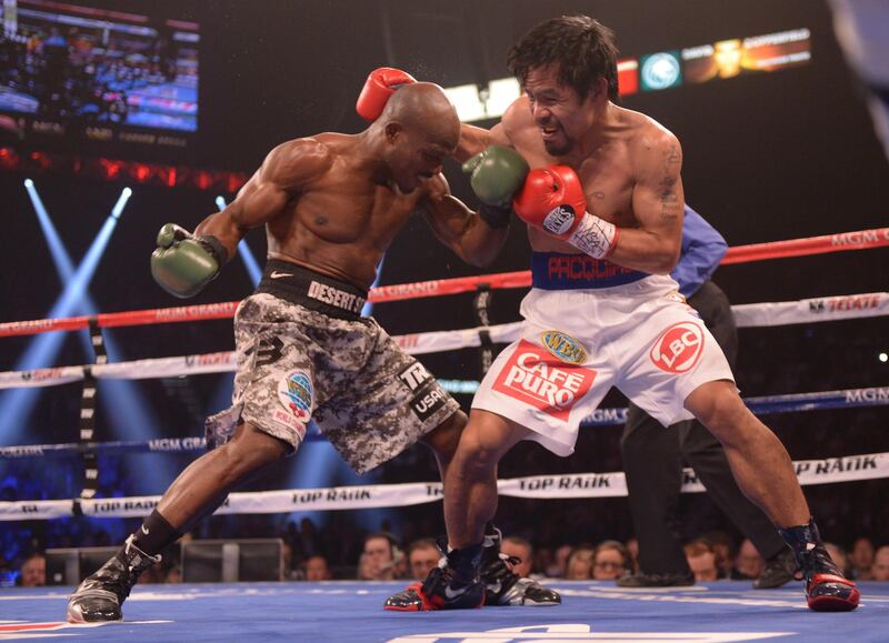 Timothy Bradley of the US (L) exchanges blows with Manny Pacquiao of Philippines (R) during their  WBO World Welterweight Championship title match at the MGM Grand Arena in Las Vegas, Nevada on April 12, 2014.    AFP PHOTO / JOE KLAMAR (Photo by JOE KLAMAR / AFP)