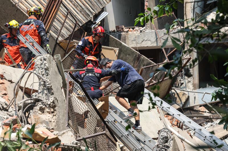 Emergency workers search the rubble of a building for survivors. AFP