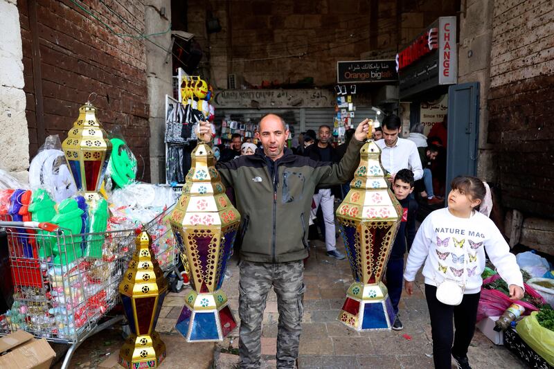 A Palestinian man tries to attract custom for his fanous in Jerusalem. AFP