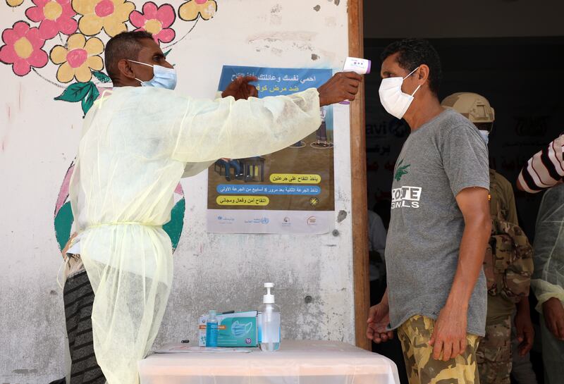 A Yemeni man has his temperature checked prior to being vaccinated. Once he receives a shot, he will be part of a tiny proportion in the conflict zone to have been inoculated against Covid. Photo: EPA