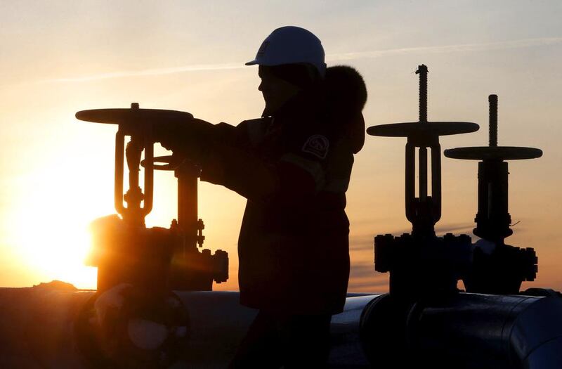 A worker checks the valve of an oil pipe at the Lukoil company owned Imilorskoye oil field outside the West Siberian city of Kogalym, Russia, on January 25, 2016. Sergei Karpukhin / Reuters