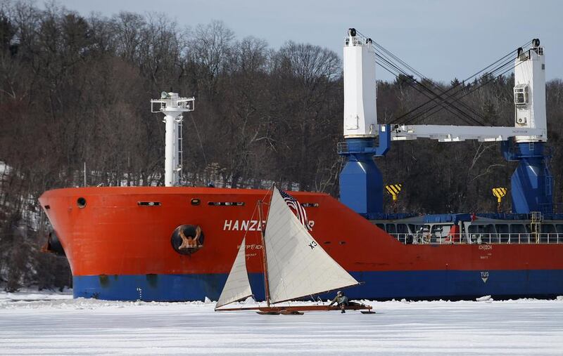 A sailboat from the Hudson River Ice Yacht Club’s sails across the ice as a ship passes through a channel in the ice. (Mike Segar / Reuters / March 7, 2014)