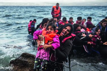 Migrants make land from an overloaded rubber dinghy as they arrive on the coast near Skala Sikaminias, Lesbos island, Greece in October. Filip Singer / EPA