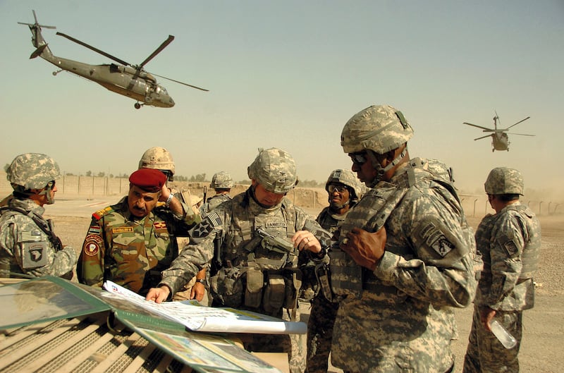 A picture released by the US military shows US army Lt. General Lloyd J. Austin III (R), commander of the XVIII Airborne Corps, Col. Jeffrey L. Bannister (C), commander of the 2nd Infantry Brigade Combat Team and Iraqi Brigadier General Abdulah (L), discussing troop progress during a field meeting outside Baghdad, Iraq, 11 September 2007. Iraqi special forces backed by US troops launched a raid 25 September 2007 against Iraq's largest military academy detaining "20 criminals". AFP PHOTO/ Spc. Nicholas A. Hernandez/US Army (Photo by SPC NICHOLAS HERNANDEZ / DOD / AFP)