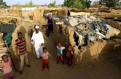 An internally displaced Sudanese family outside their makeshift shelter  in Darfur, Sudan. Reuters