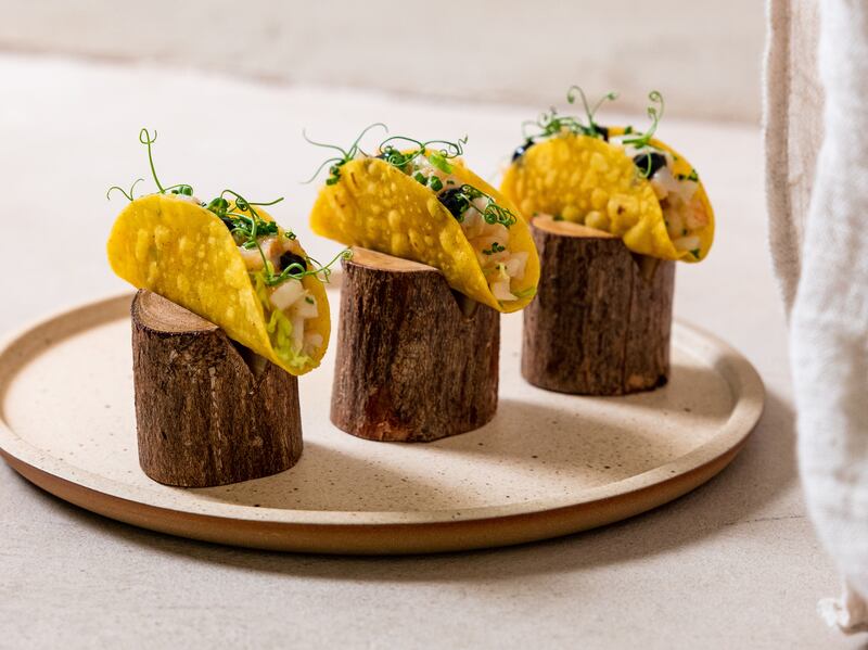 Mini taquito of Emirati shrimps with lime, green curry paste, coconut milk, black garlic and chives. Photo: Erth