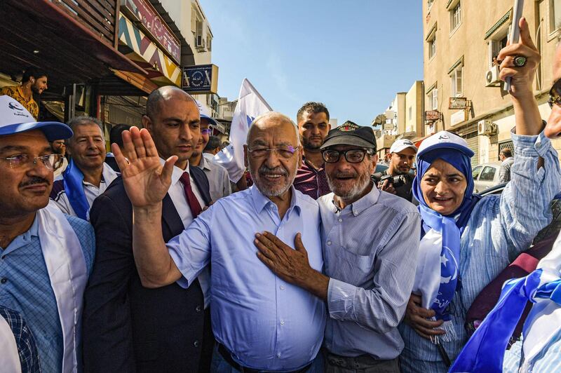 Ennahdha Party leader Rached Ghannouchi poses for a picture with supporters while campaigning for his party ahead of the legislative elections in Tunisia's capital Tunis. AFP