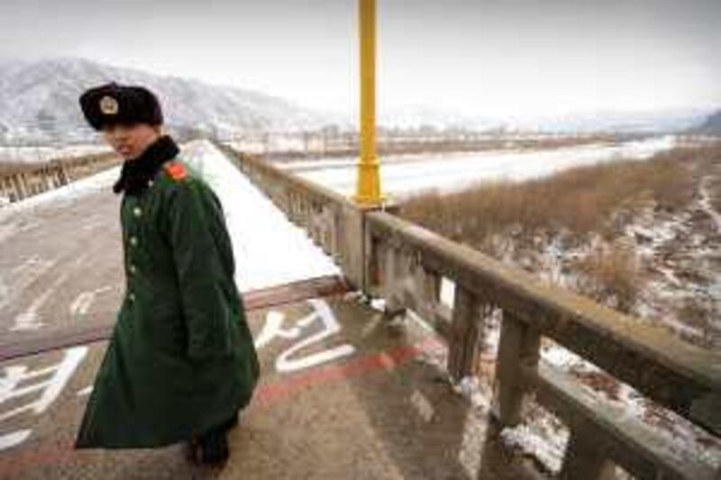 A Chinese border guard in the town of Tumen in China's Jilin province patrols on a bridge over the Tumen river leading to the North Korea town of Namyang on March 21, 2009.  North Korea confirmed on March 21 that it had detained two US journalists along the border with China earlier this week after the US State Department had expressed concern over the fate of the two women, who were believed to have been taken into custody by border guards patrolling the Tumen river.     AFP PHOTO/Peter PARKS *** Local Caption ***  Hkg2217395.jpg