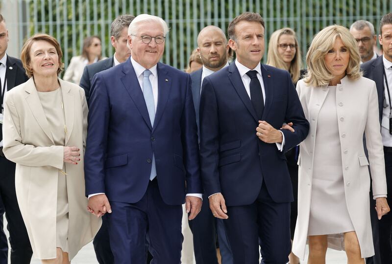 German President Frank-Walter Steinmeier (2ndL) and his wife Elke Buedenbender (L) walk with French President Emmanuel Macron (2ndR) and his wife Brigitte Macron (R) past the Chancellery on their way to attend a debate as part of the Festival of Democracy (Demokratiefest) on May 26, 2024 in Berlin.  The French president pays a three-day state visit to Germany until May 28.  The festival celebrates the 75th anniversary of Germany's Basic Law.  (Photo by Ludovic MARIN  /  AFP)