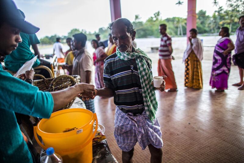 Flood victims wait in line to pick up tea and snacks at a relief camp set up at Sree Narayana College Cherthala, affiliated to the University of Kerala, in Alappuzha, Kerala, India, on Thursday, Aug. 23, 2018. India's tourist hub of Kerala is shifting its focus to relief and rehabilitation work to assist millions of people affected by the worst flood in a century as rescue operations wind down. Photographer: Prashanth Vishwanathan/Bloombergg