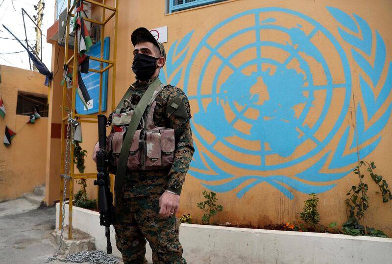 A Palestinian fighter from the Fatah movement wears a mask to help curb the spread of the coronavirus as he stands guard at the closed entrance of Jalil, or Galilee Palestinian refugee camp, in Baalbek, Lebanon, Friday, April 24, 2020. Authorities closed all entrances to a Palestinian refugee camp in eastern Lebanon Friday after four more people tested positive for the coronavirus, heightening concerns over the virus spreading among the population of overcrowded refugee camps and settlements. (AP Photo/Hussein Malla)