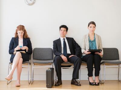 Business people in office waiting room. Getty Images