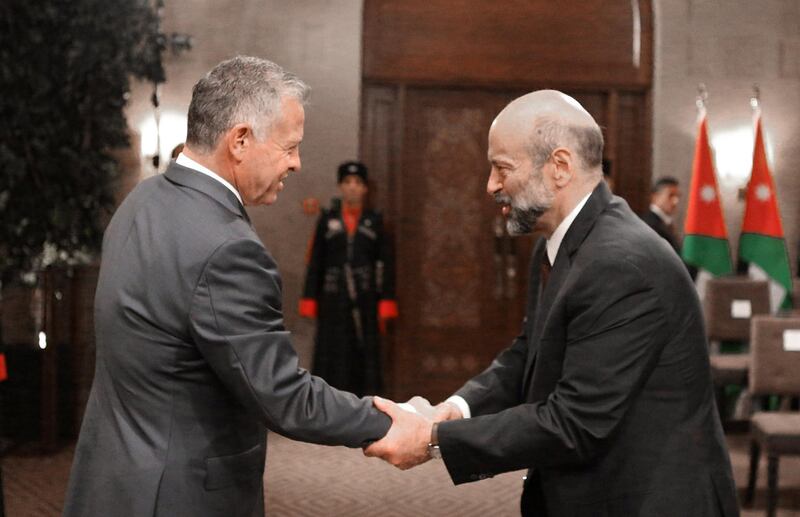 Jordan's King Abdullah II shakes hands with Prime Minister Omar al-Razzaz during a swearing-in ceremony of the new cabinet in Amman, Jordan June 14, 2018. Jordanian Royal Palace/Handout via Reuters ATTENTION EDITORS - THIS IMAGE HAS BEEN SUPPLIED BY A THIRD PARTY. FOR EDITORIAL USE ONLY.