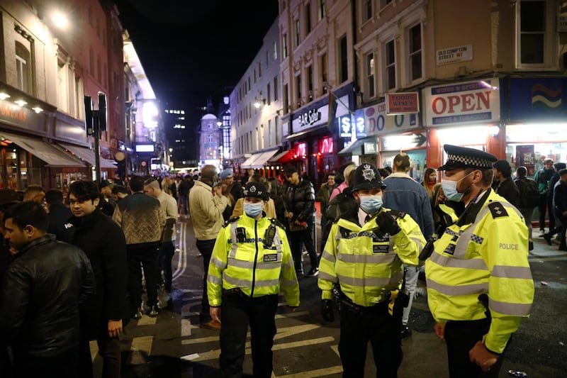 Metropolitan Police officers on patrol as people gather on a street in Soho in London. Reuters