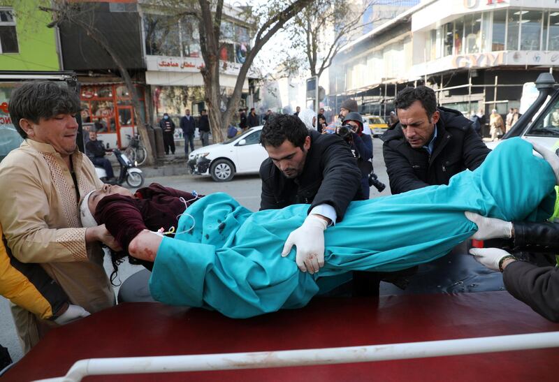 Men carry an injured person to a hospital after rockets hit residential areas in Kabul, Afghanistan. REUTERS
