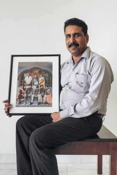 Devassy Thomas receives the picture of his family with the portrait of him. Courtesy Waleed Shah and Nikith Nath