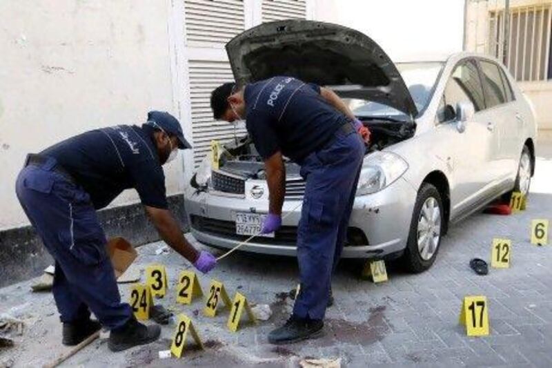 Police collect evidence at the site of a bombing where a migrant worker was killed in the Manama suburb of Gudaibiya.