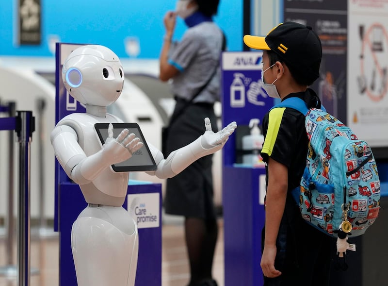 Pepper, a semi-humanoid robot manufactured by SoftBank Robotics, informs passengers about the new rules to prevent the spread of Covid-19 at Tokyo International Airport at Haneda in Japan.  EPA