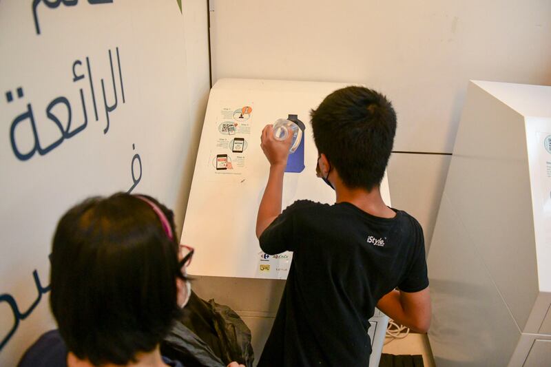 Rowena Mercado and her son Jaydean Mercado, 14, use the Cycle machine for the first time to recycle the plastic bottles at World Trade Centre Mall, Abu Dhabi.
