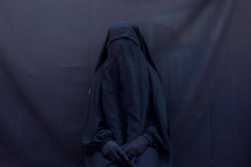 In this Sept. 9, 2019, photo, Yazidi Layla Taloo poses for a portrait in the full-face veil and abaya she wore while enslaved by Islamic State militants, at her home in Sharia, Iraq. Taloo’s 2 1/2-year ordeal in captivity underscores how IS members continually ignored the rules the group tried to impose on the slave system. “They explained everything as permissible. They called it Islamic law. They raped women, even young girls,” said Taloo, who was owned by eight men. (AP Photo/Maya Alleruzzo)