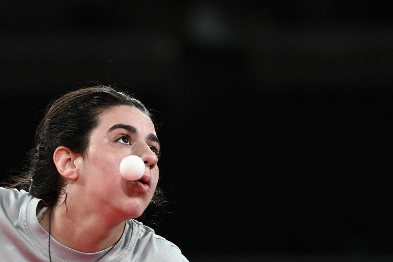 Syria's Hend Zaza serves to Austria's Liu Jia.