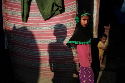 In this Sunday, Sept. 10, 2017, photo, a young Rohingya stands outside her temporary shelter at a camp in Kathmandu, Nepal. Recent violence in Myanmar has driven hundreds of thousands of Rohingya Muslims to seek refuge across the border in Bangladesh. Only about 250 Rohingya live in Nepal since anti-Muslim riots erupted in Myanmar in 2012, according to the U.N. refugee agency, which offers them education and medical support. The refugees live in a ramshackle camp carved out on a slope on the outskirts of the capital, Kathmandu. Their huts of tin, bamboo and plastic sheets are connected by narrow stone steps. (AP Photo/Niranjan Shrestha)