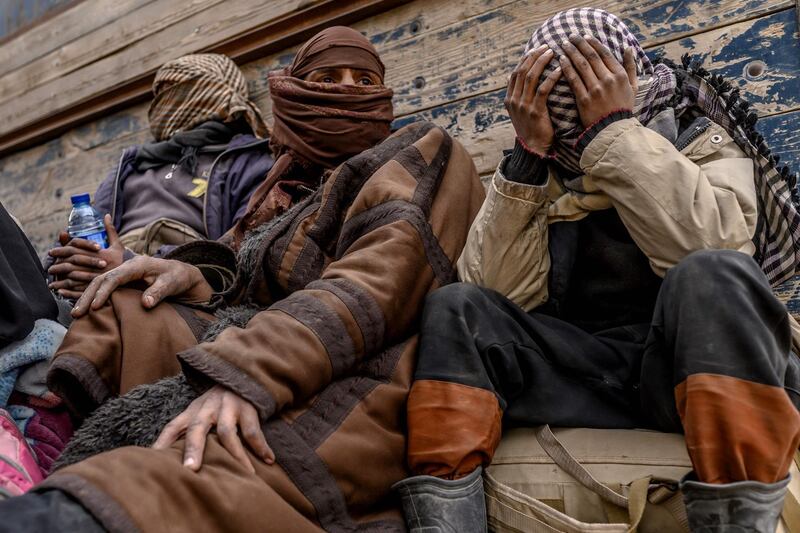 CORRECTION / Men suspected of being Islamic State (IS) wait to be searched by members of the Kurdish-led Syrian Democratic Forces (SDF) after leaving the IS group's last holdout of Baghouz, in Syria's northern Deir Ezzor province on February 27, 2019.  / AFP / Bulent KILIC
