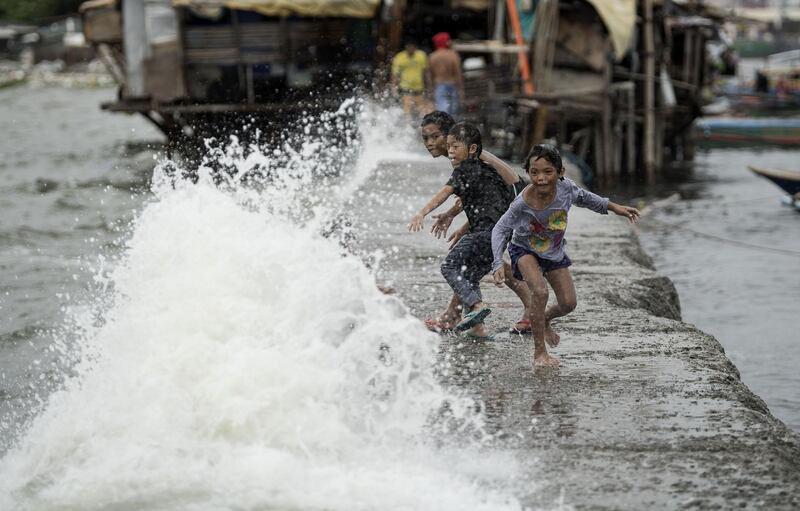 Children run along on the sea wall of Manila Bay as Tropical Depression Henry approaches northern parts of the Philippines. Noel Celis/AFP