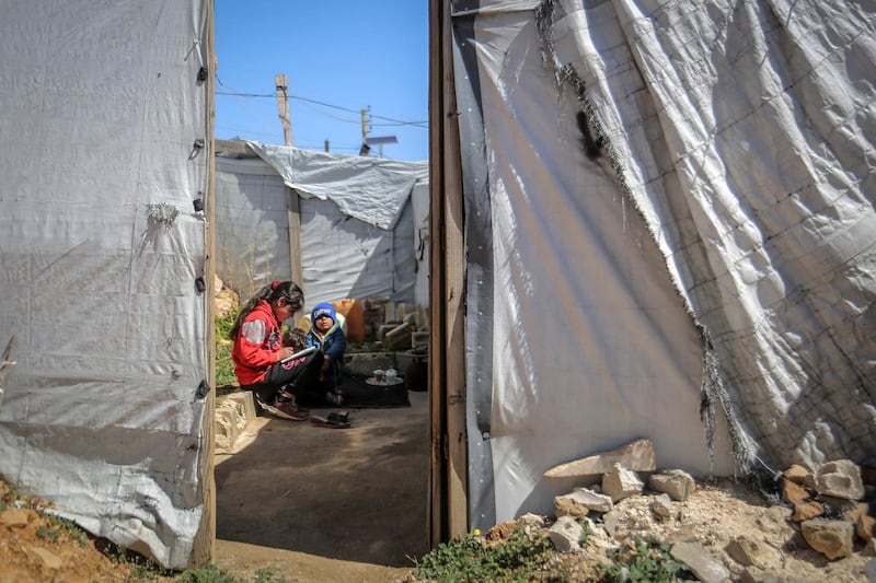 13 March 2021, Lebanon, Aarsal: Rahma, a 13-year-old Syrian refugee girl sits with her six-year-old brother Mohamad outside their tent at the Barra refugee camp in the Lebanese town of Aarsal, located north-east of capital Beirut. UNICEF said that after 10 years since the start of the Syrian conflict, war has left the lives and futures of a generation of children hanging by a thread. The Syrian war remains one of the world's most complex humanitarian crises as it continues to ravage many areas in Syria. Photo: Marwan Naamani/dpa (Photo by Marwan Naamani/picture alliance via Getty Images)