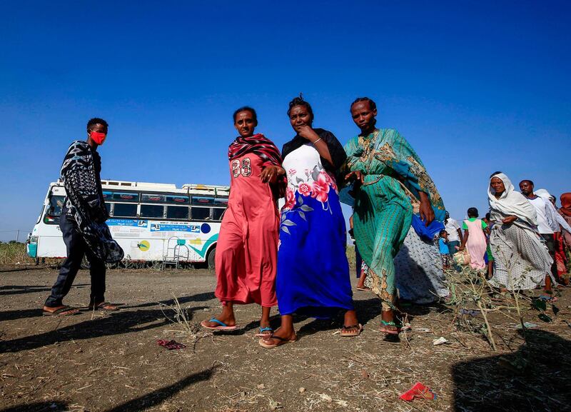 Ethiopian refugees who fled fighting in the Tigray Region walk by at the Village 8 border reception center in Sudan's eastern Gedaref State. AFP