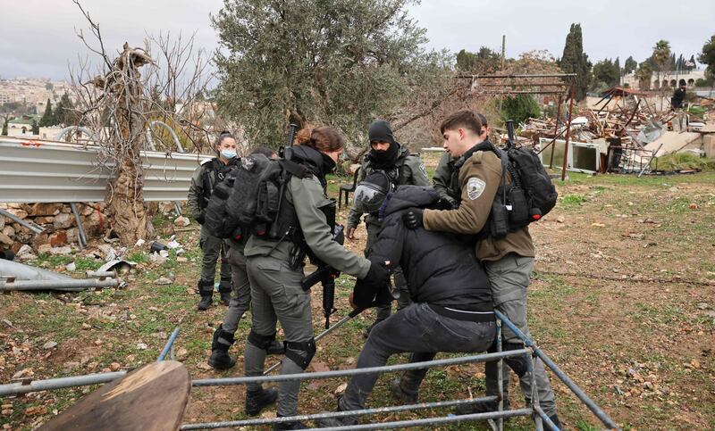 Israeli officers drag the man away from the site. Residents had barricaded themselves inside the home on Monday, before it was demolished. AFP
