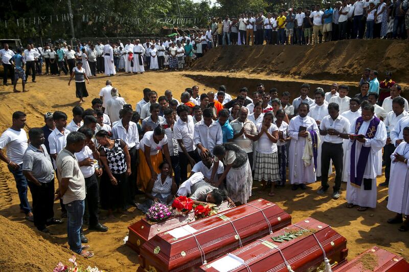 People react during a mass burial of victims, two days after a string of suicide bomb attacks on churches and luxury hotels across the island on Easter Sunday, at a cemetery near St. Sebastian Church in Negombo, Sri Lanka April 23, 2019. REUTERS/Athit Perawongmetha