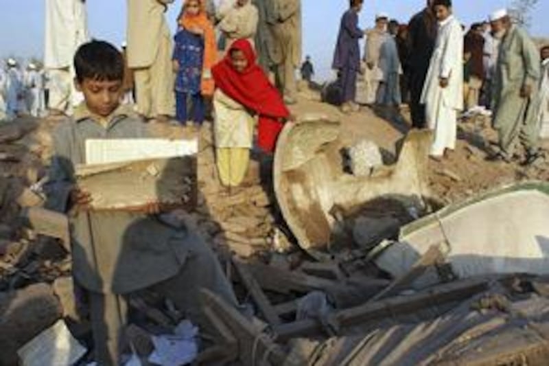 Children collect stationery from the debris of a girls' school after it was bombed by militants in Pakistan's Khyber tribal region yesterday.