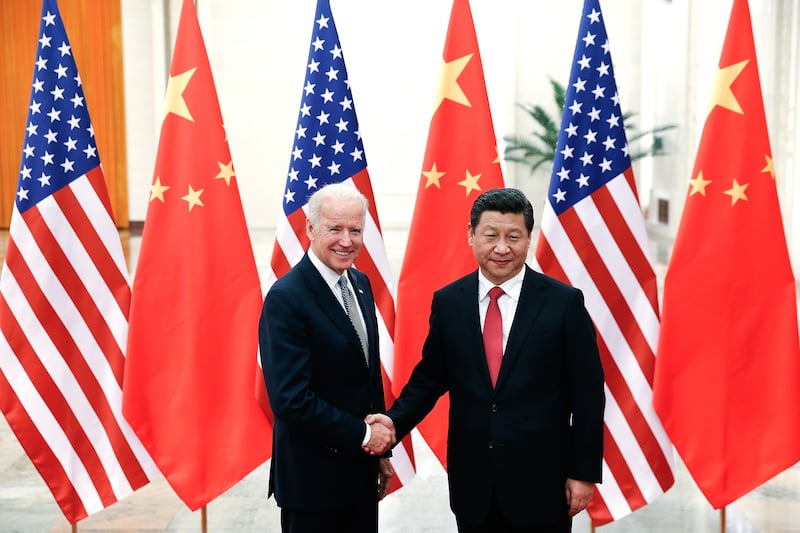The pair shake hands in the Great Hall of the People in Beijing in December 2013. Getty