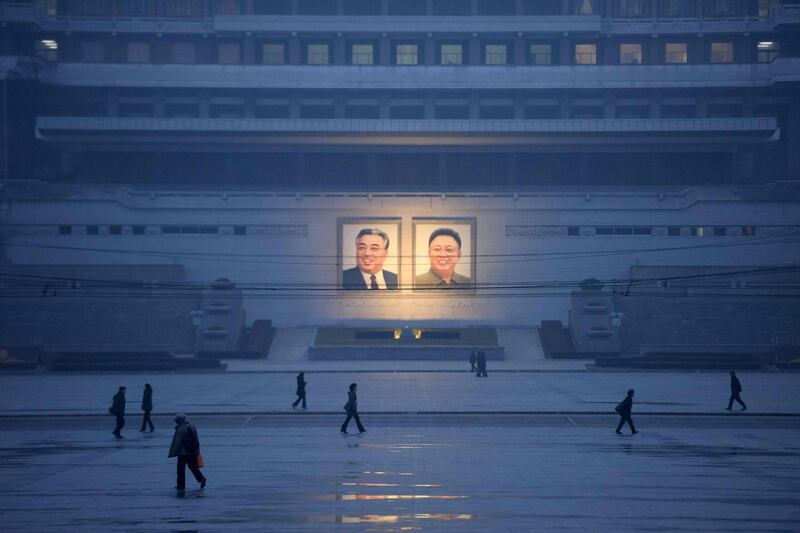 Pedestrians walk past portraits of late North Korean leaders Kim Il Sung and Kim Jong Il in Pyongyang. AFP