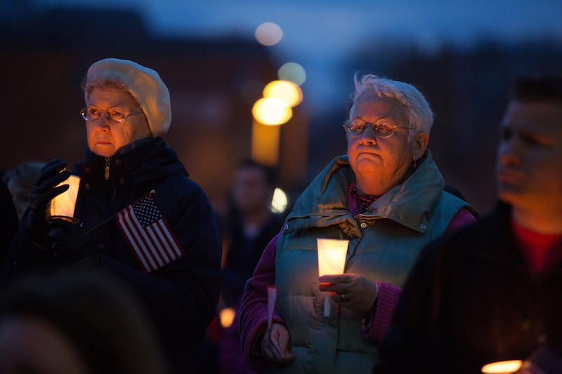 Mourners hold candles and U.S. flags during a vigil for Martin Richard, one of three killed in the Boston Marathon bombings, at Garvey Park in Boston, Massachusetts, U.S., on Tuesday, April 16, 2013. Richard, an 8-year-old from Boston's Dorchster neighborhood, was among the dead in blasts that also injured his mother and sister. Photographer: Scott Eisen/Bloomberg *** Local Caption ***  1201339.jpg
