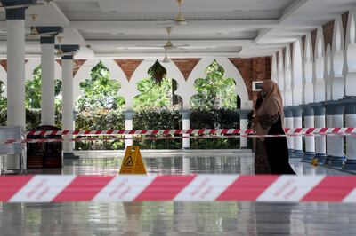 A woman wearing a protective mask walks at a mosque following the outbreak of coronavirus, in Kuala Lumpur, Malaysia March 16, 2020. REUTERS/Lim Huey Teng