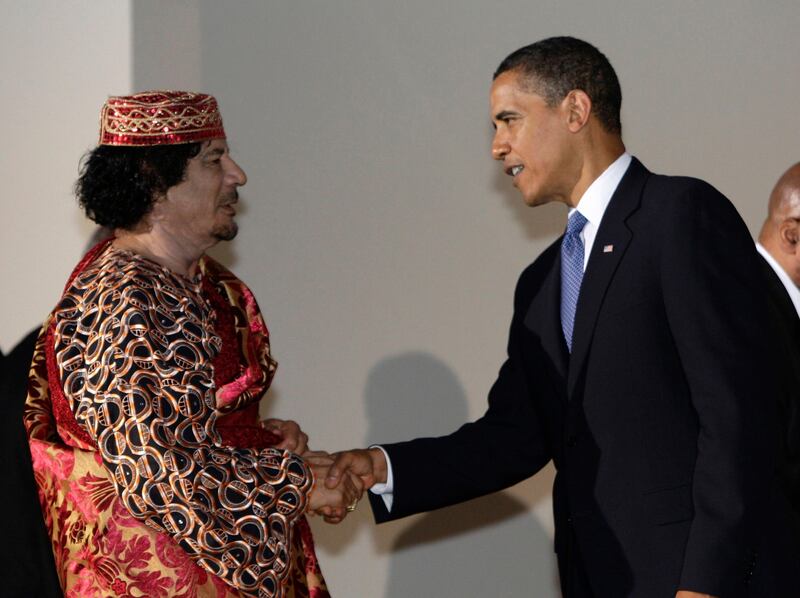 U.S. President Barack Obama shakes hands with Libya's leader Muammar Gaddafi (L) before a dinner at the G8 summit in L'Aquila in this July 9, 2009 file photo. Gaddafi died of wounds suffered on October 20, 2011 as fighters battling to complete an eight-month-old uprising against his rule overran his hometown Sirte, Libya's interim rulers said. His killing, which came swiftly after his capture near Sirte, is the most dramatic single development in the Arab Spring revolts that have unseated rulers in Egypt and Tunisia and threatened the grip on power of the leaders of Syria and Yemen. REUTERS/Alessandro Bianchi/Files (ITALY - Tags: POLITICS) *** Local Caption ***  SIN308_LIBYA_1020_11.JPG