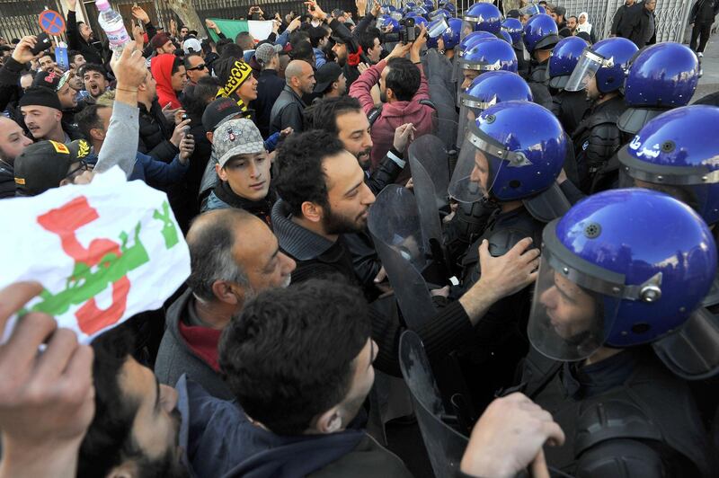 Riot police hold back demonstrators to prevent them marching towards the presidential palace. AP