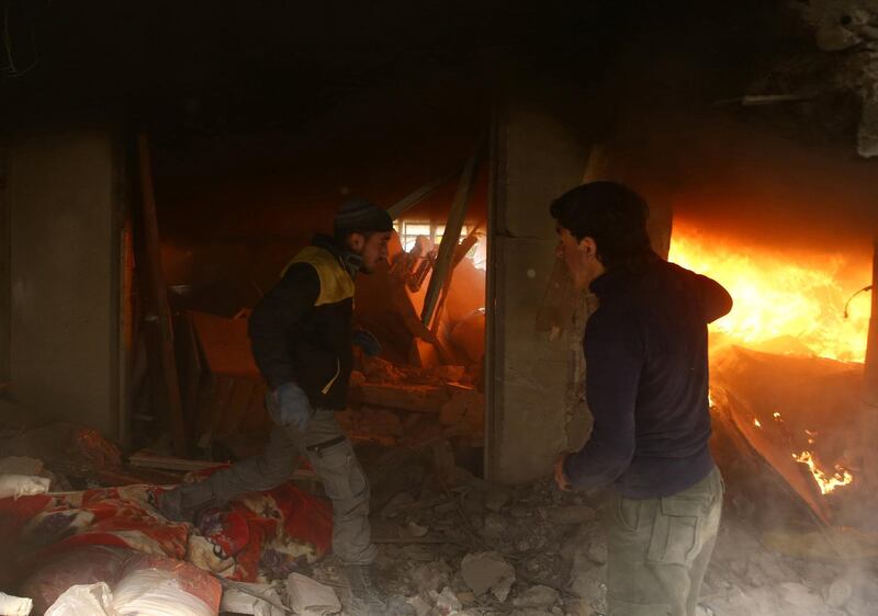 Rescuers race through the rubble of a building set on fire by Syrian government air strikes on Douma on February 7, 2018. Bassam Khabieh / Reuters