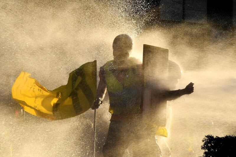 Protesters are showered by a water cannon as they clash with police during a "yellow vest" demonstration in Bordeaux, western France. AFP