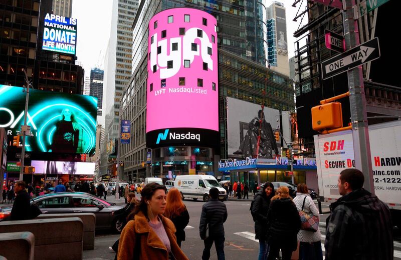 (FILES) In this file photo taken on March 29, 2019 The Lyft logo is shown on the screen at the Nasdaq offices in Times Square in New York.  Uber and Lyft are hoping a courtroom reprieve will spare them from shutting down their rival smartphone-summoned ride services in California on August 21. The companies are awaiting word from an appeals court whether they will be able to delay having to abide by a new state law that officials argue requires them to reclassify drivers as employees entitled to worker benefits. / AFP / Don EMMERT
