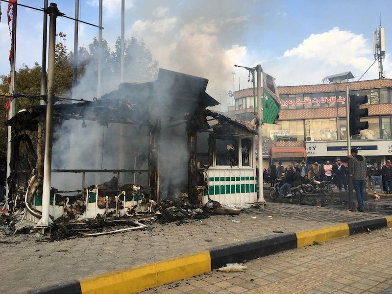 Iranians gather around a charred police station that was set ablaze by protesters during a demonstration against a rise in gasoline prices in the central city of Isfahan on November 17, 2019. President Hassan Rouhani warned  that riot-hit Iran could not allow "insecurity" after two days of unrest killed two people and saw authorities arrest dozens and restrict internet access. Rouhani defended the controversial petrol price hike that triggered the protests -- a project which the government says will finance social welfare spending amid a sharp economic downturn
 / AFP / -
