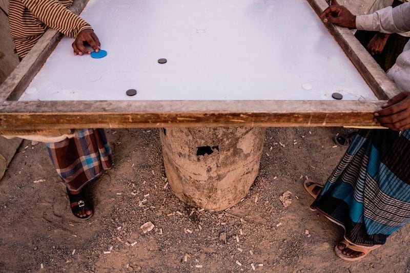 With few options for recreation, labourers spend the early evening  
playing games such as  'lamboard', while drinking cups of tea and  
smoking cigarettes.