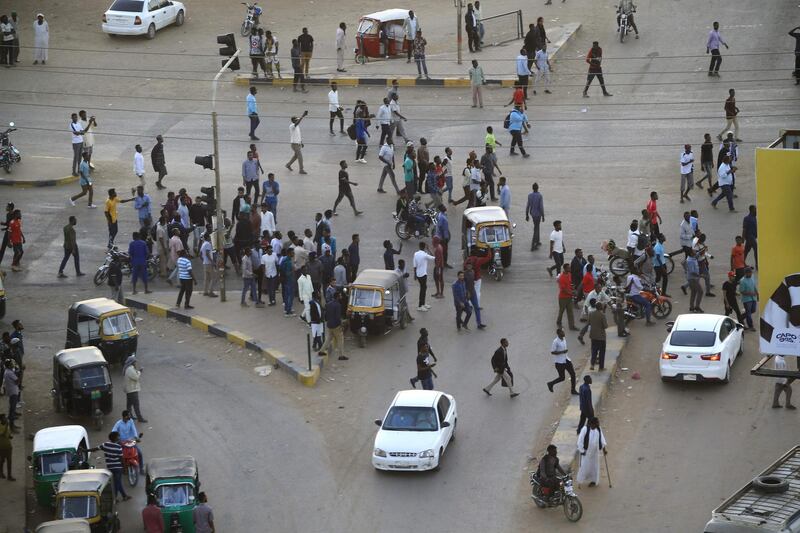 People gather outside the headquarters of the Directorate of General Intelligence Service in Khartoum after members of Sudan's intelligence services shot bullets in the air, in the Riyadh district of the capital. AFP