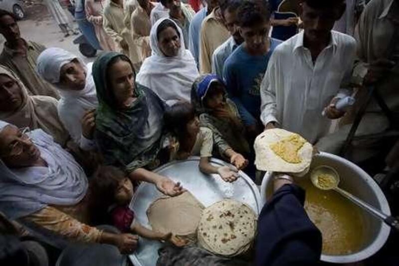 Hands out: People wait to get government food rations outside the Data Durbar mosque in Lahore, one of the better places to be poor in Pakistan according to humanitarian agencies.