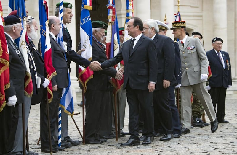 French president Francois Hollande shakes hands with members of veterans associations during a ceremony in which he acknowledged the state's responsibility in abandoning Algerians who fought alongside French colonial forces in Algeria's war for independence, in Paris, Sunday, Sept. 25, 2016. (Ian Langsdon/Pool Photo via AP)