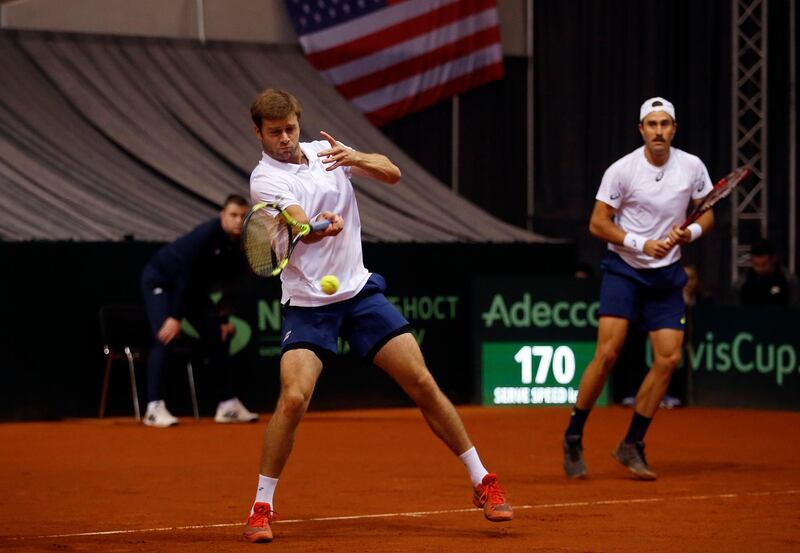 United States' Steve Johnson, right, watches teammate Ryan Harrison return the ball to Serbia's Nikola Milojevic and Miljan Zekic during their Davis Cup World Group first round tennis match in Nis, Serbia, Saturday, Feb. 3, 2018. (AP Photo/Darko Vojinovic)